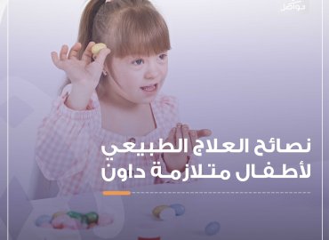 طفلة جميلة مصابة بمتلازمة داون تحمل معها لعبة وهي مبتسمة