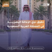 جل كفيف يسير في شارع واسع محاط بأشجار النخيل والمباني، يرتدي ثوبًا أبيض وغترة حمراء ويضع نظارة داكنة، ممسكًا بعصا بيضاء على الصورة مكتوب: حقوق ذوي الإعاقة البصرية في المملكة العربية السعودية