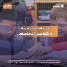 صورة لطفلين من ذوي الإعاقة البصرية يرتديان نظارات طبية، يجلسان معًا أمام كتاب مفتوح 